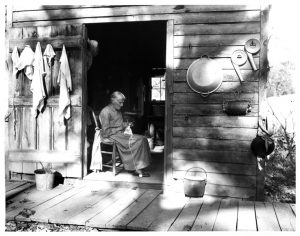 Photos - A old woman knitting on a porch.